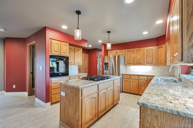 a kitchen with stainless steel appliances granite countertop a sink stove and refrigerator