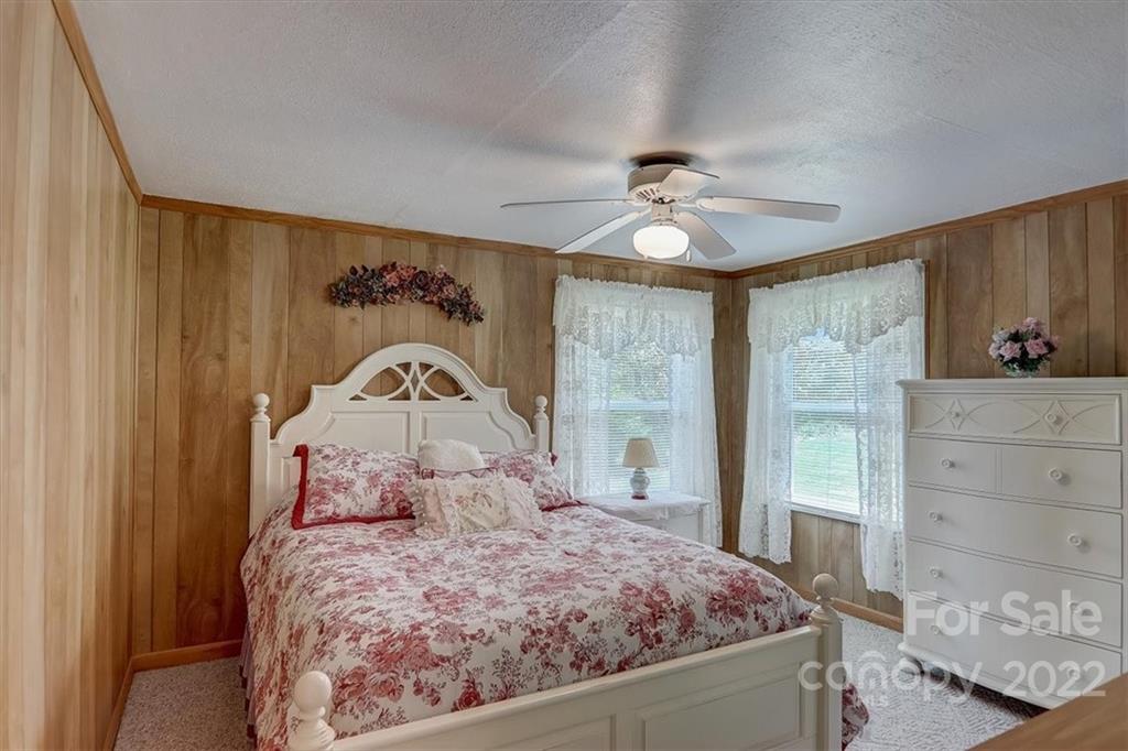115 Substation Road Canton, NC 28716 - Photo 19 of 41 a bedroom with a bed and a chandelier