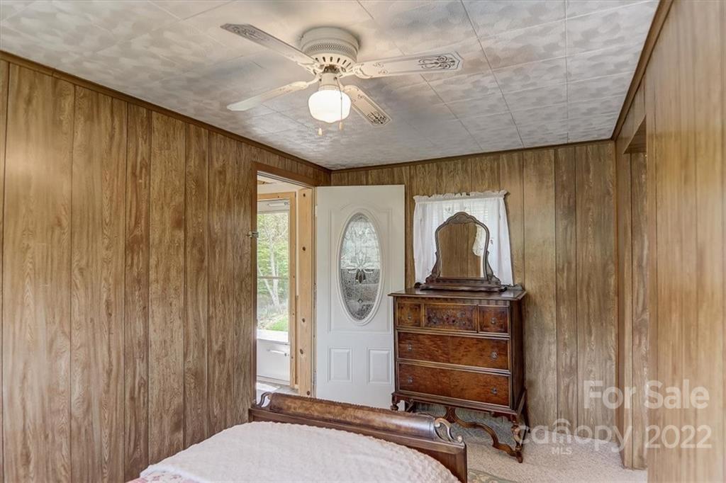115 Substation Road Canton, NC 28716 - Photo 26 of 41 a bedroom with a bed and a chandelier