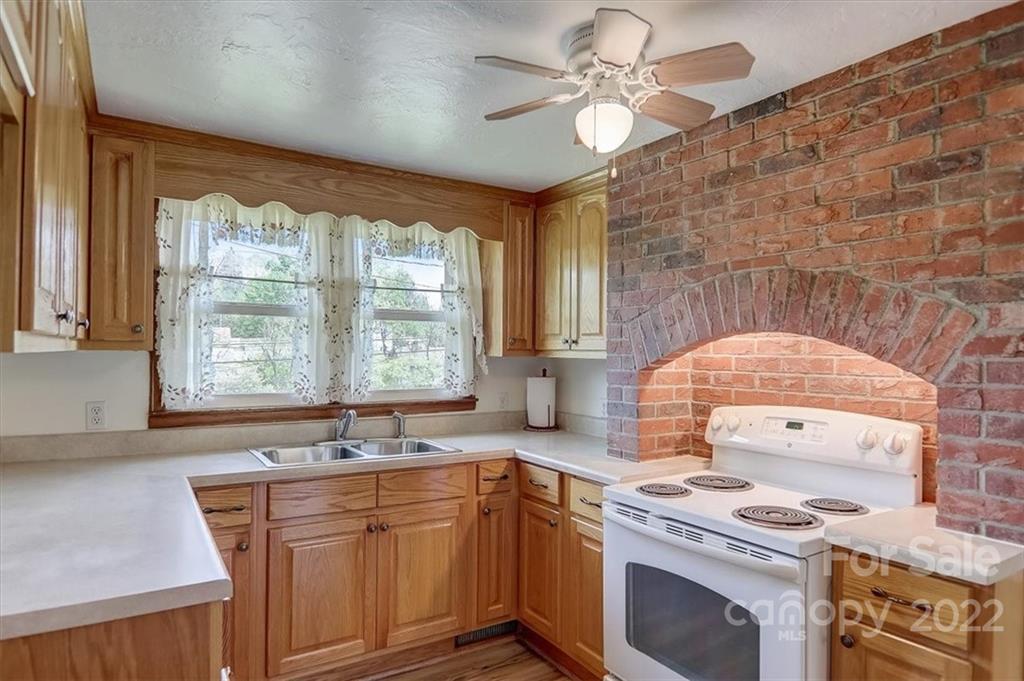 115 Substation Road Canton, NC 28716 - Photo 41 of 41 a kitchen with stainless steel appliances granite countertop a sink a stove and a granite counter tops with a large window