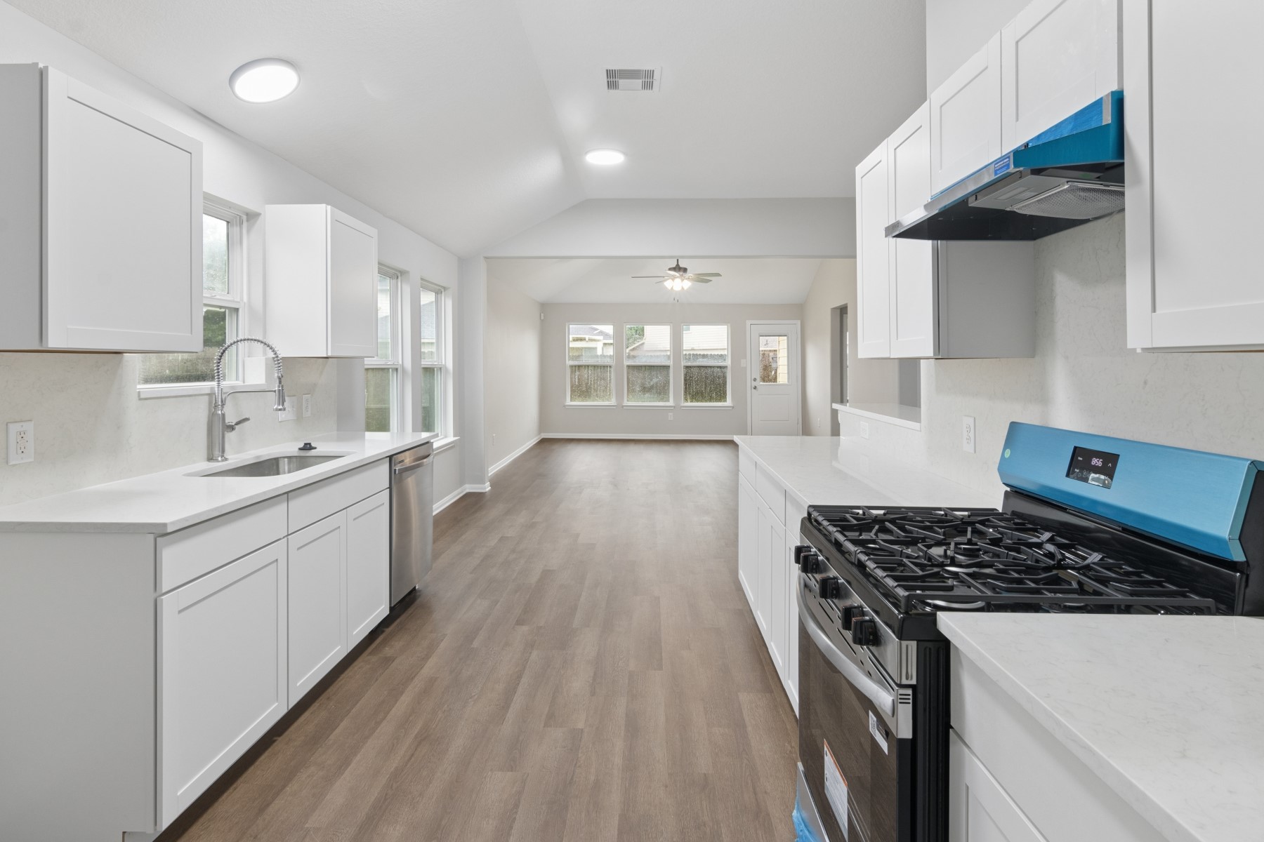 7811 Adonis Avenue Baytown, TX 77521 - Photo 18 of 36 a kitchen with stainless steel appliances a sink dishwasher stove and white cabinets with wooden floor