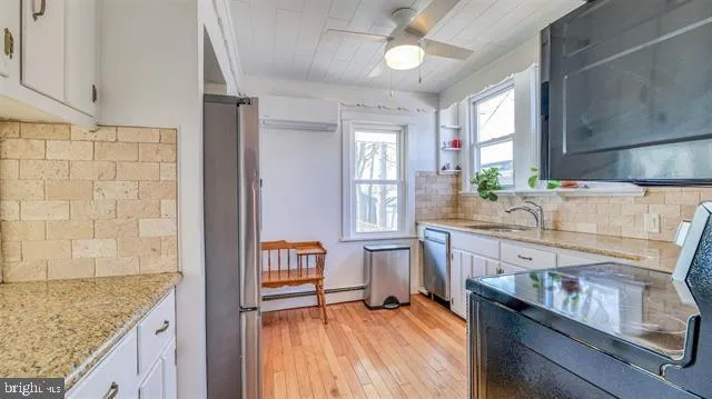 a kitchen with granite countertop a sink stove and cabinets