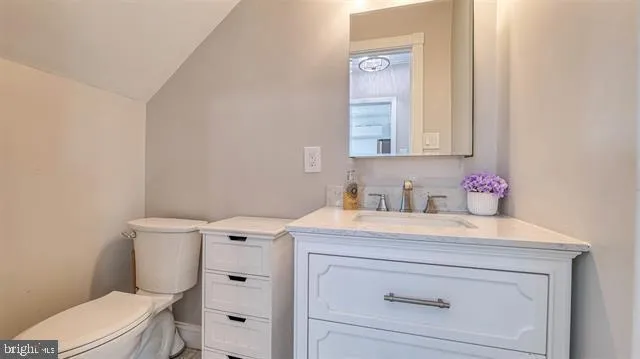 a bathroom with a sink vanity mirror and toilet