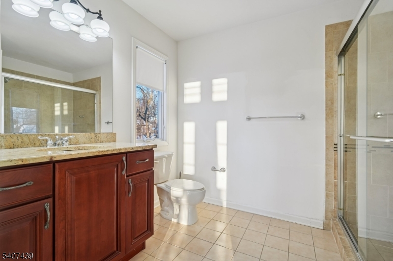 282 South Street, Unit B New Providence, NJ 07974 - Photo 18 of 28 a bathroom with a granite countertop sink a toilet a mirror and shower