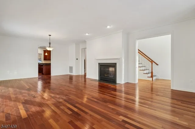 a view of empty room with wooden floor and fireplace