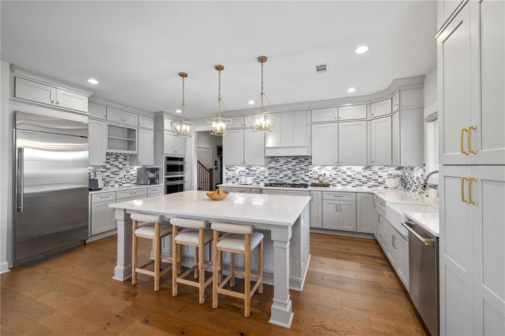 815 North Hampton Way Monroe, GA 30656 - Photo 19 of 89 a kitchen with kitchen island granite countertop lots of wooden cabinets stainless steel appliances and white cabinets