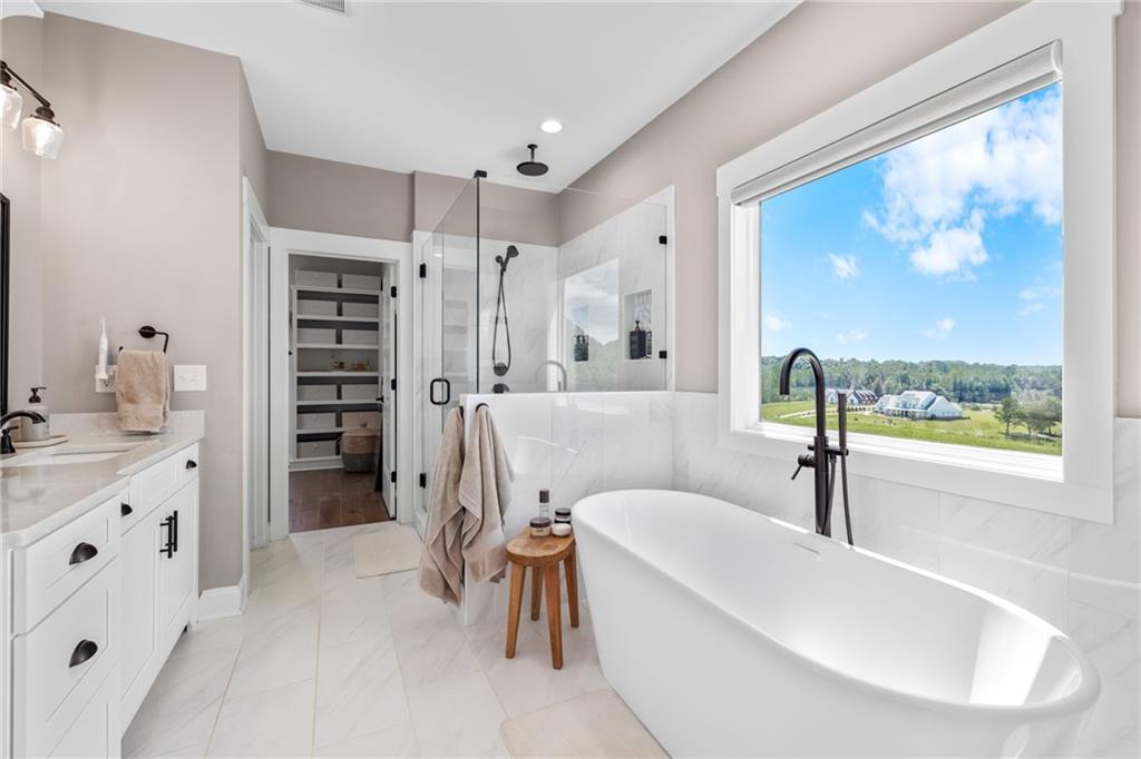 815 North Hampton Way Monroe, GA 30656 - Photo 28 of 89 a spacious bathroom with a tub a double vanity sink a mirror a window and a shower
