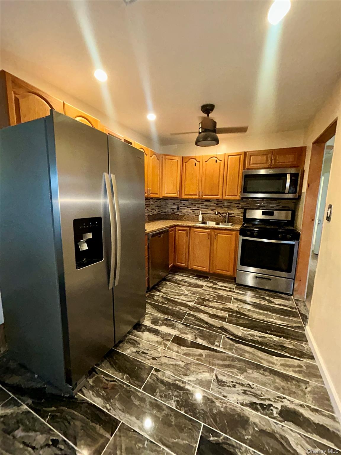 1255 Udall Road Bay Shore, NY 11706 - Photo 2 of 8 Kitchen with appliances with stainless steel finishes, recessed lighting, brown cabinets, and light countertops