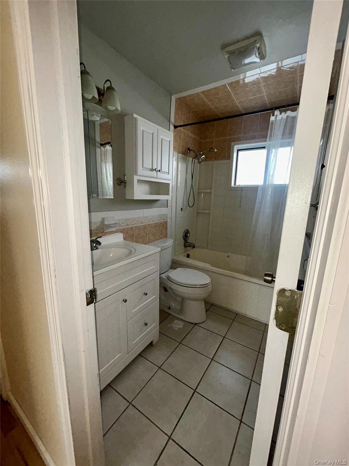 1255 Udall Road Bay Shore, NY 11706 - Photo 4 of 8 Full bathroom featuring vanity, tiled shower / bath, and light tile patterned floors