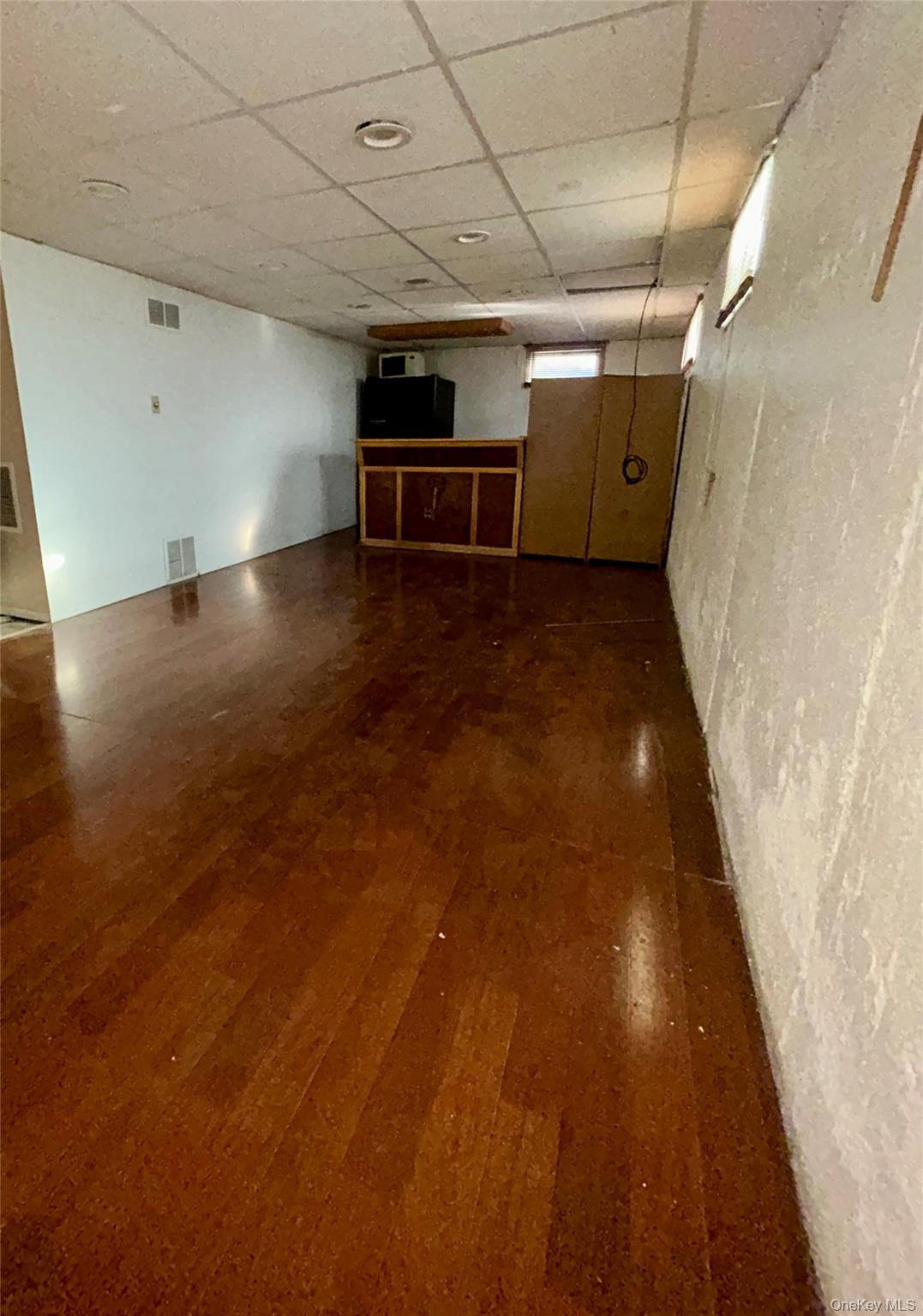 1255 Udall Road Bay Shore, NY 11706 - Photo 5 of 8 Finished below grade area featuring a drop ceiling and dark wood-style floors