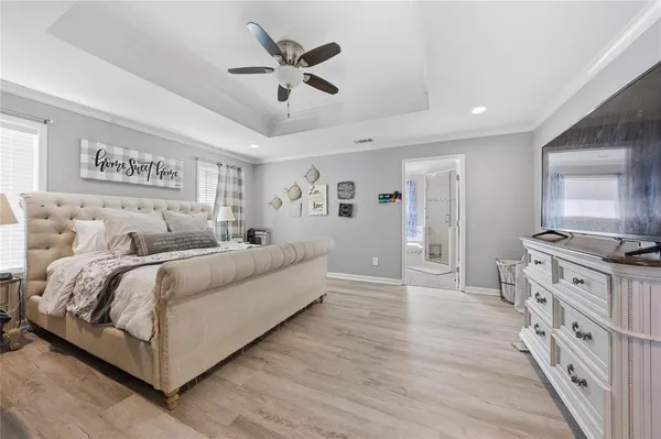 a spacious bedroom with a bed and a chandelier
