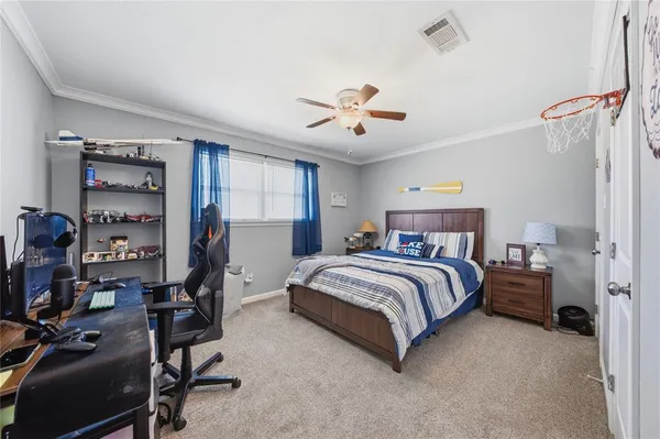 a spacious bedroom with a bed and a chandelier