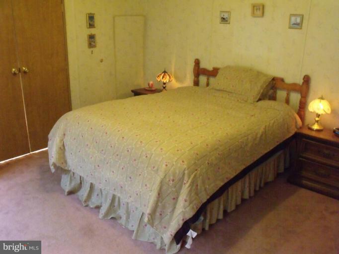 10505 Cedarville Road, Unit 1015 Brandywine, MD 20613 - Photo 12 of 26 a bed sitting in a bathroom next to a wooden wall