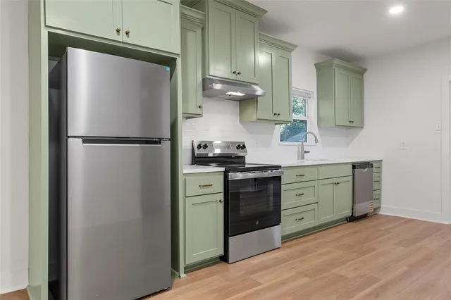 a kitchen with a refrigerator sink and stove