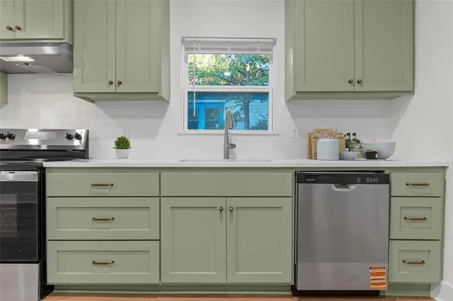 a kitchen with white cabinets and a window