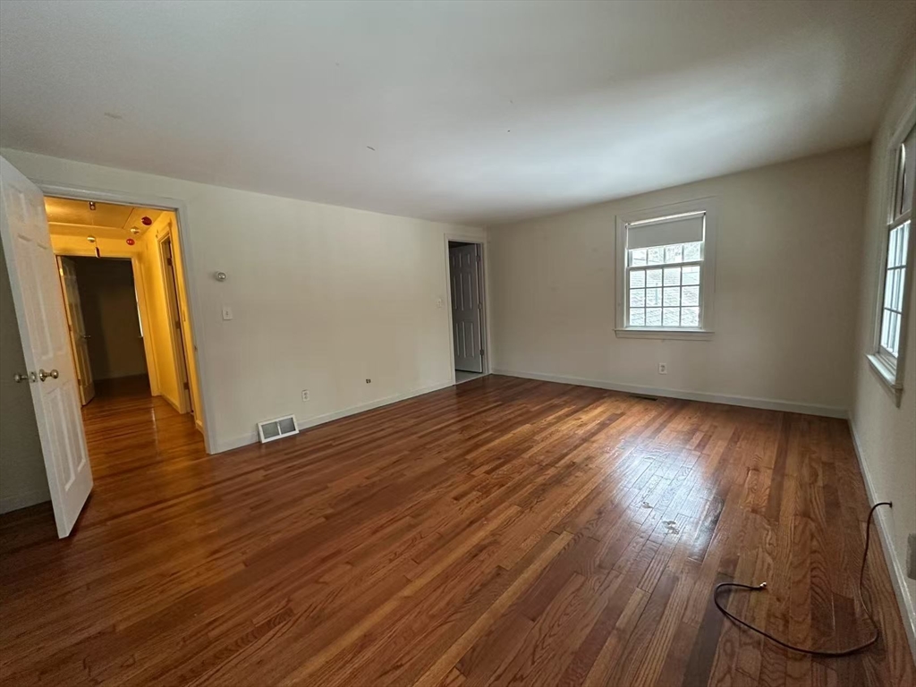 73 Jericho Road, Unit 73 Weston, MA 02493 - Photo 12 of 12 an empty room with wooden floor and windows