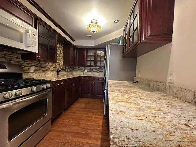 a kitchen with stainless steel appliances granite countertop a stove and a sink