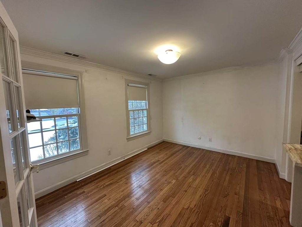 73 Jericho Road, Unit 73 Weston, MA 02493 - Photo 10 of 12 an empty room with wooden floor and windows