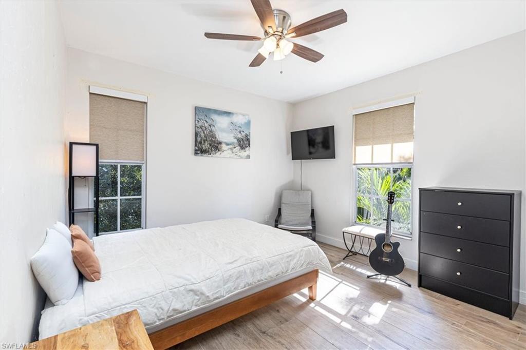 3618 Cottage Club Lane Naples, FL 34105 - Photo 16 of 26 a bedroom with a bed a window and a flat screen tv