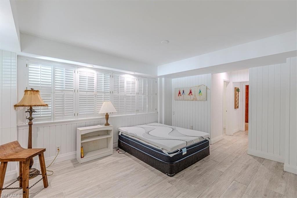 3618 Cottage Club Lane Naples, FL 34105 - Photo 17 of 26 a bedroom with a bed and a chandelier