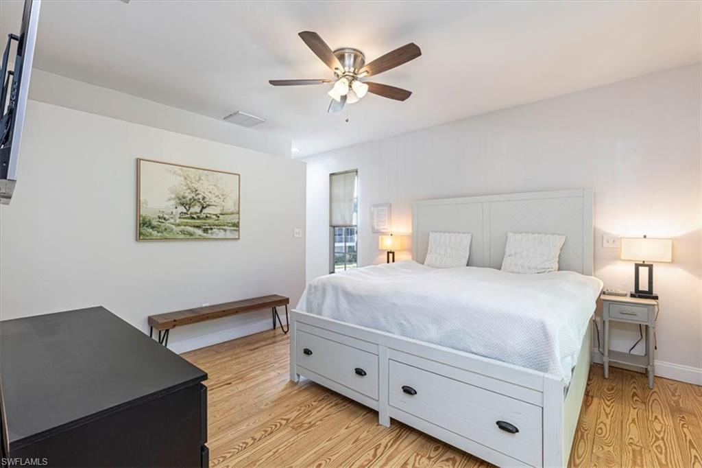 3618 Cottage Club Lane Naples, FL 34105 - Photo 18 of 26 a bedroom with bed and a chandelier