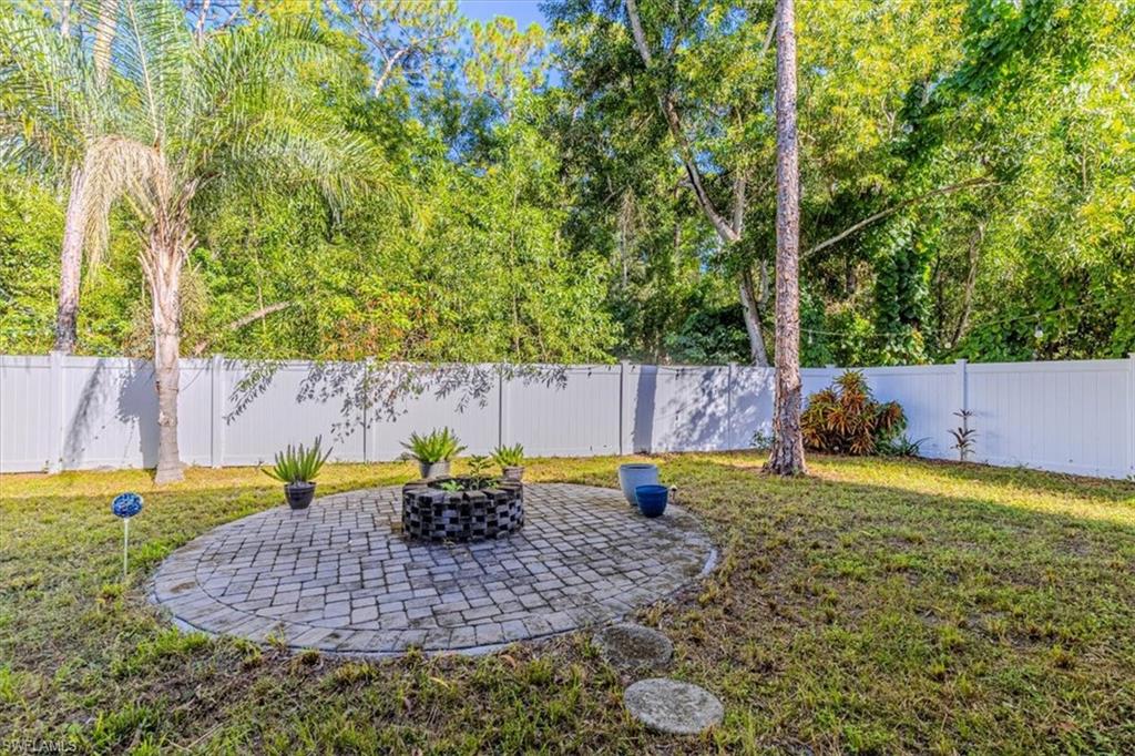 3618 Cottage Club Lane Naples, FL 34105 - Photo 22 of 26 a backyard of a house with table and chairs