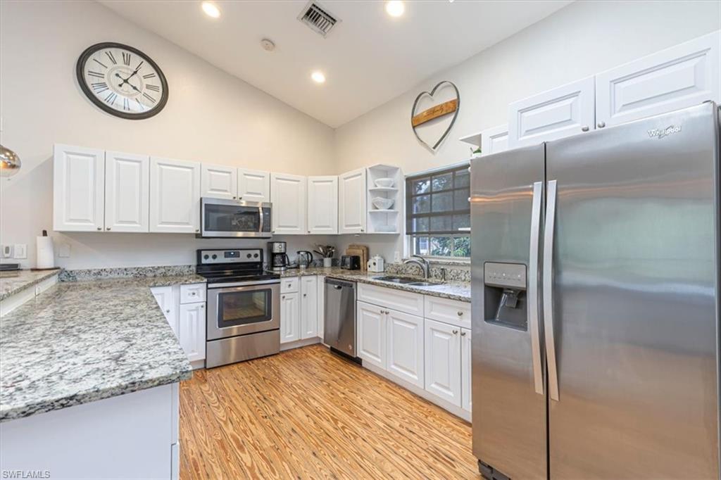 3618 Cottage Club Lane Naples, FL 34105 - Photo 5 of 26 a kitchen with stainless steel appliances granite countertop a stove a refrigerator and a sink