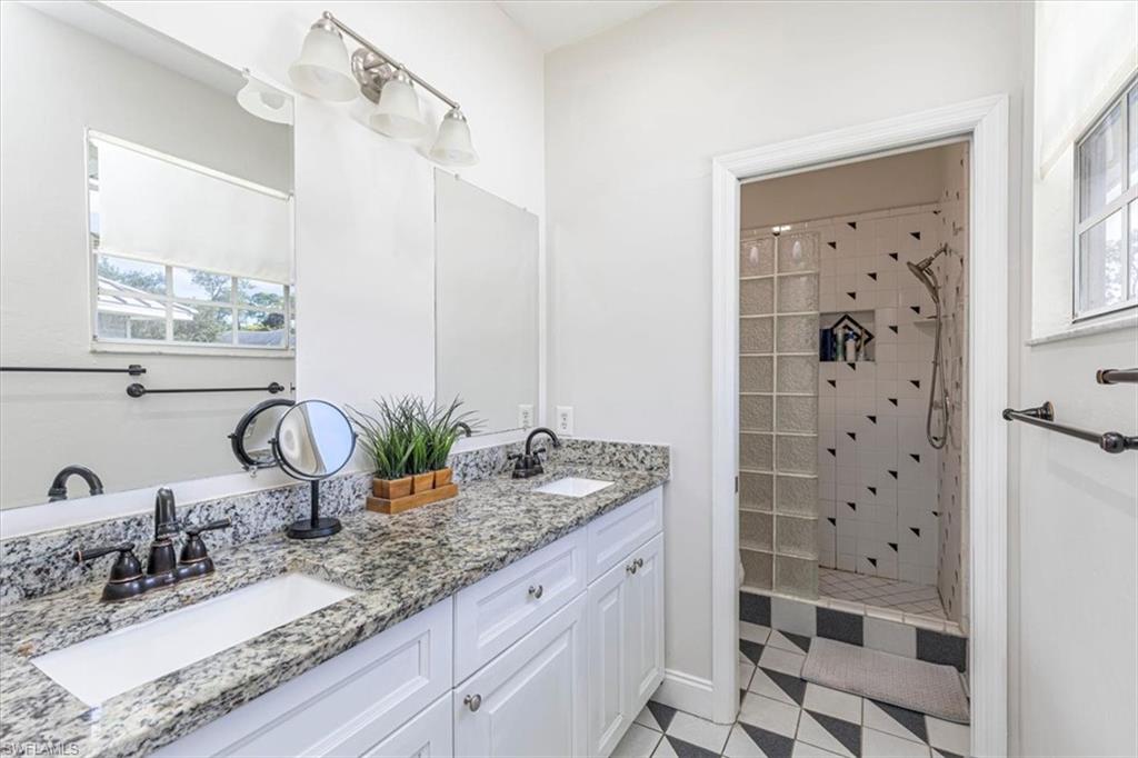 3618 Cottage Club Lane Naples, FL 34105 - Photo 7 of 26 a bathroom with a granite countertop sink a mirror and shower