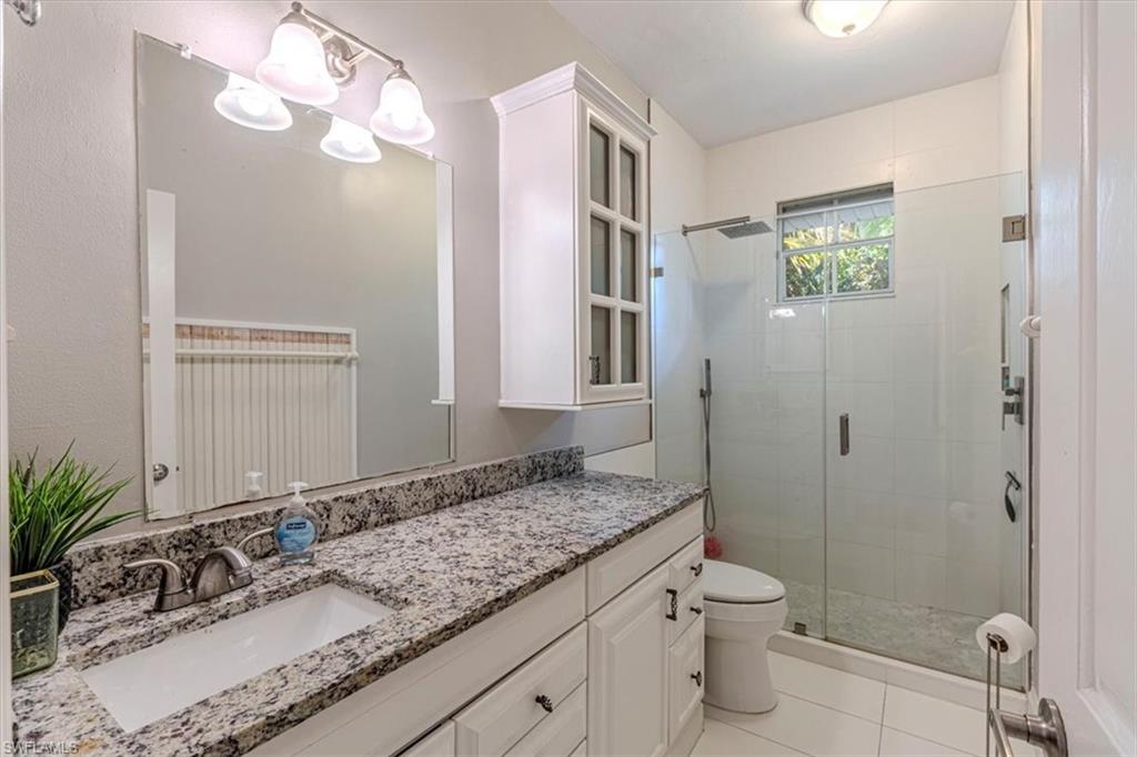 3618 Cottage Club Lane Naples, FL 34105 - Photo 10 of 26 a bathroom with a granite countertop sink a toilet and shower