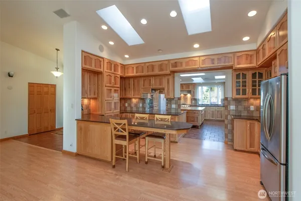 a kitchen with stainless steel appliances granite countertop a refrigerator and a stove top oven