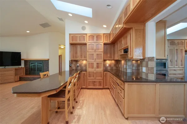 a dining hall with stainless steel appliances granite countertop a stove and a sink