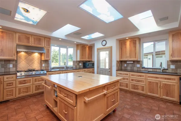 a large kitchen with kitchen island a sink stove and wooden floor