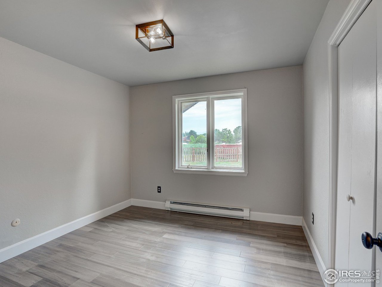 7823 Hygiene Road Longmont, CO 80503 - Photo 15 of 21 an empty room with wooden floor and windows