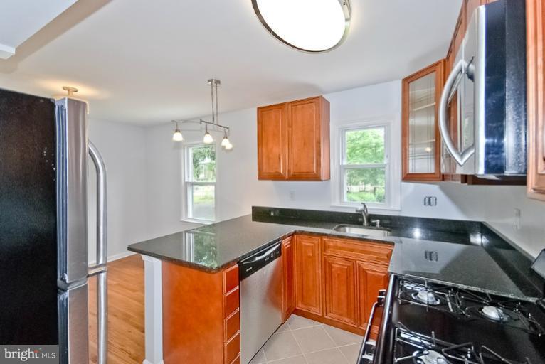 6600 Riggs Road Hyattsville, MD 20783 - Photo 17 of 24 a kitchen with stainless steel appliances granite countertop a sink stove and refrigerator