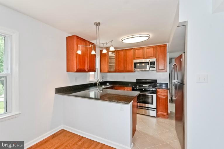 6600 Riggs Road Hyattsville, MD 20783 - Photo 21 of 24 a kitchen with stainless steel appliances granite countertop a sink stove and refrigerator