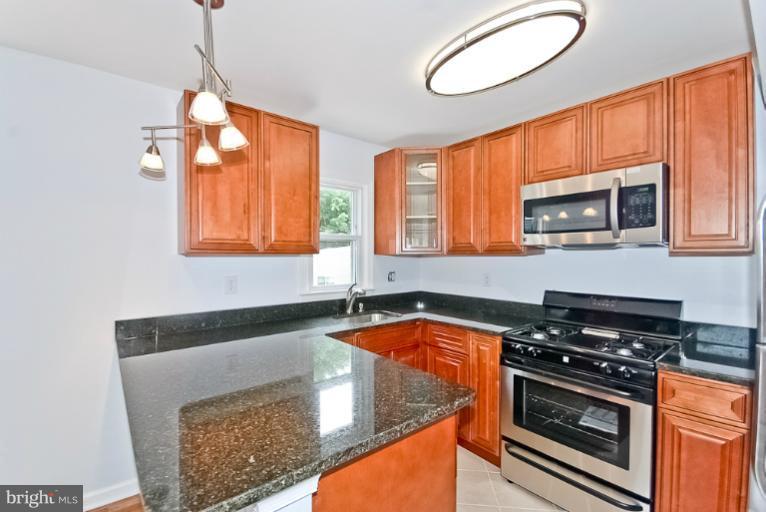 6600 Riggs Road Hyattsville, MD 20783 - Photo 4 of 24 a kitchen with stainless steel appliances granite countertop a stove a sink and a microwave