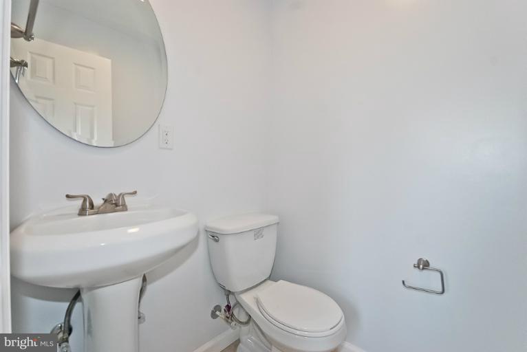 6600 Riggs Road Hyattsville, MD 20783 - Photo 7 of 24 a bathroom with a toilet a sink and mirror