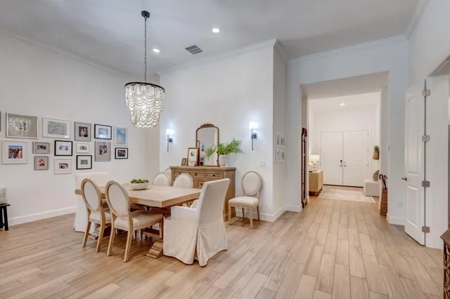 a view of a dining room with furniture a chandelier and wooden floor