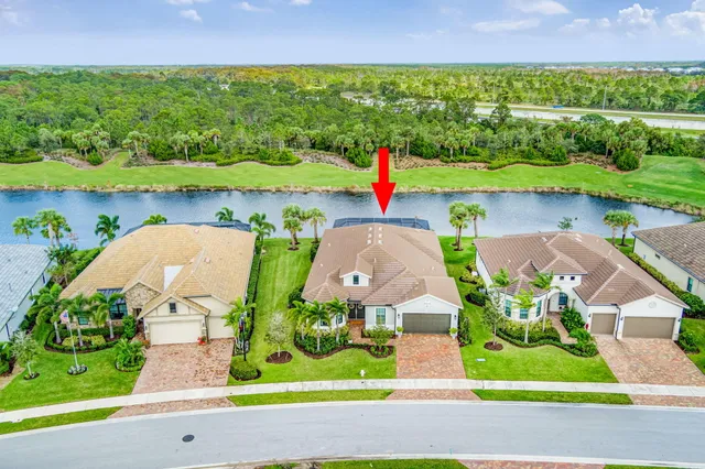 an aerial view of a house with a yard and lake view