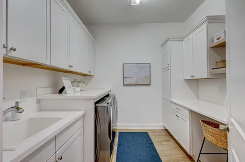 a utility room with cabinets washer and dryer