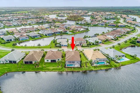 an aerial view of a house with a garden and lake view