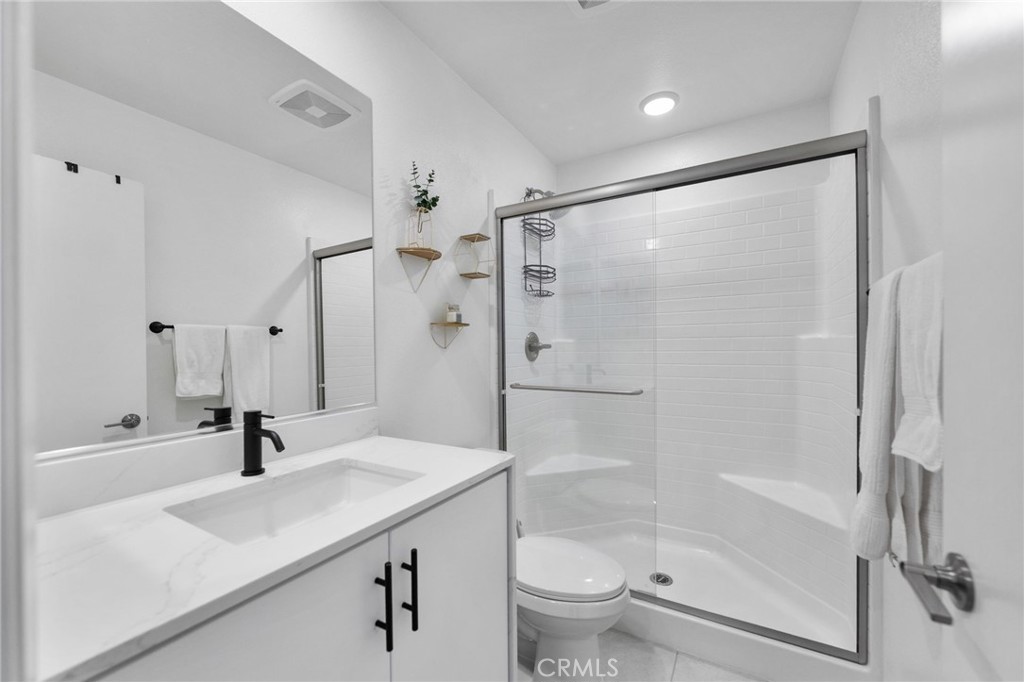 303 Sweet Place Fallbrook, CA 92028 - Photo 21 of 59 a bathroom with a shower sink vanity mirror and toilet