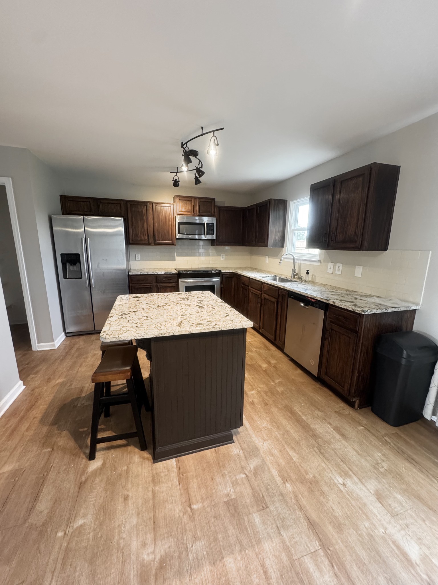 4017 Cadence Drive Spring Hill, TN 37174 - Photo 12 of 38 a living room with stainless steel appliances furniture a kitchen island a table and chairs