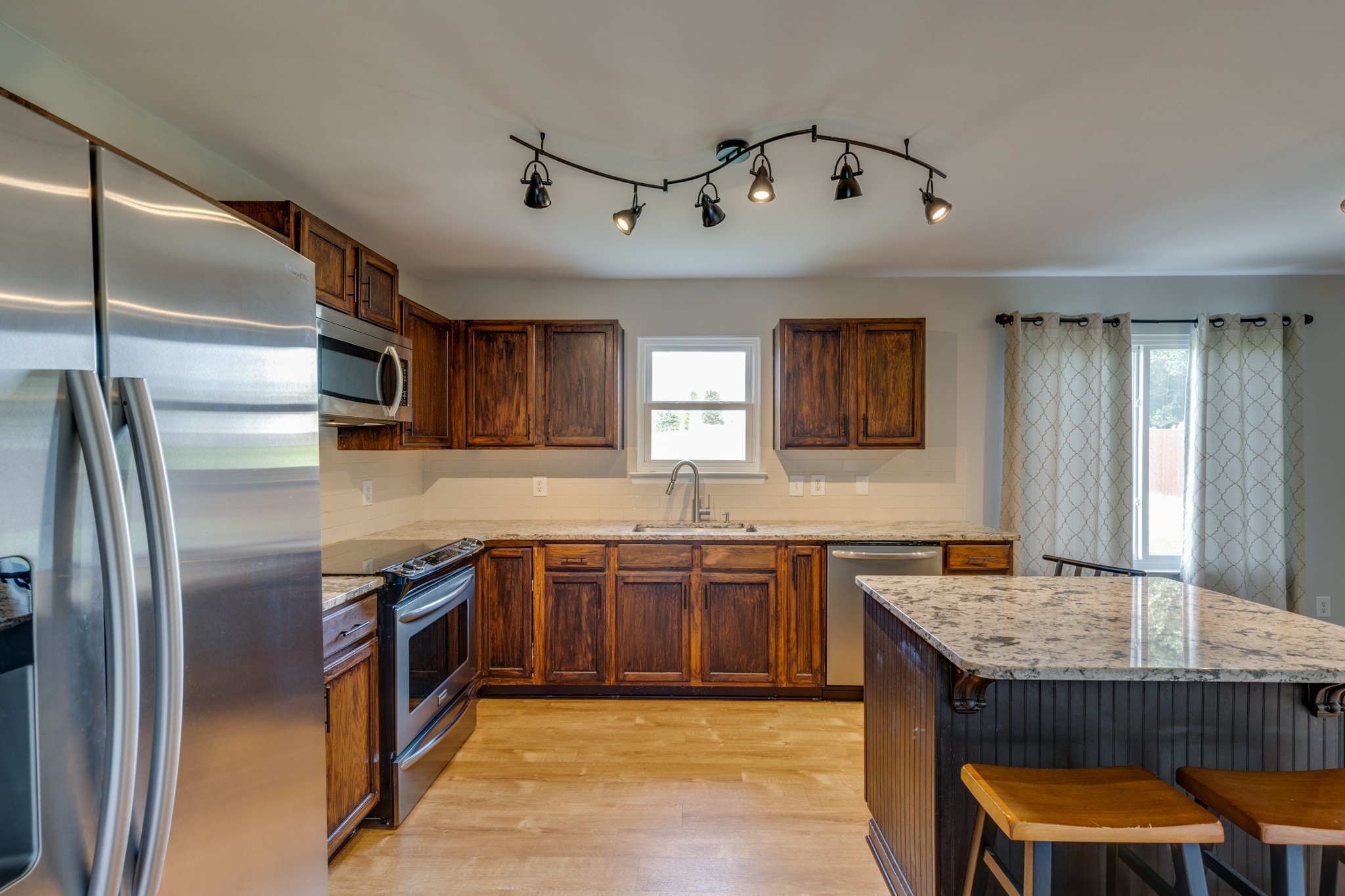 4017 Cadence Drive Spring Hill, TN 37174 - Photo 6 of 38 a kitchen with stainless steel appliances granite countertop a sink dishwasher stove and refrigerator