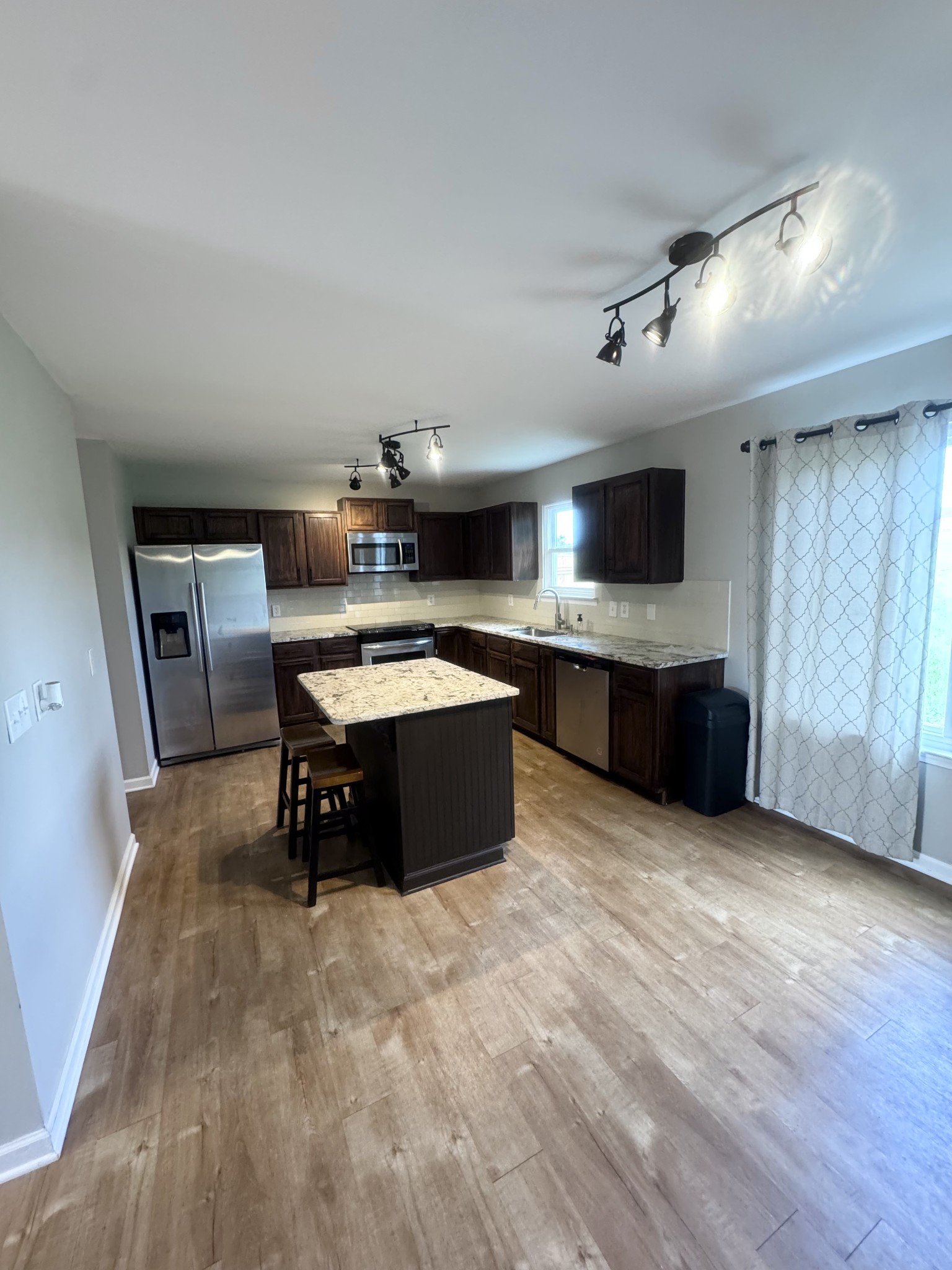 4017 Cadence Drive Spring Hill, TN 37174 - Photo 8 of 38 a large kitchen with stainless steel appliances granite countertop a stove and a sink