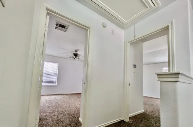 a view of a hallway with closet and a fireplace