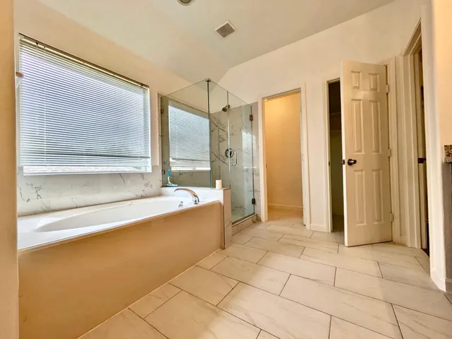 a bathroom with a tub shower and sink