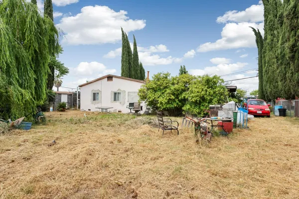 a backyard of a house with table and chairs