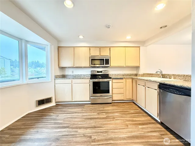 a kitchen with granite countertop white cabinets and white appliances