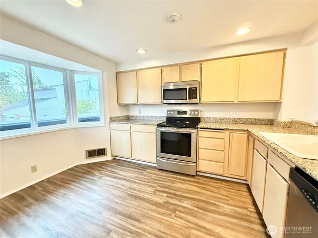 a kitchen with granite countertop white cabinets and white appliances
